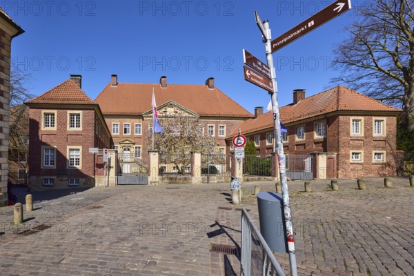 Cathedral administration, brick building, bollards, cobblestone pavement, signpost to