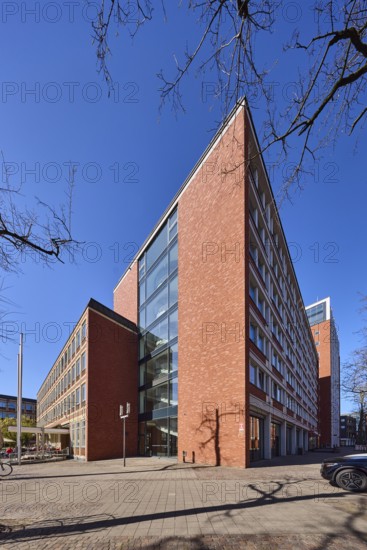 Stadthaus 1, city centre, brick building, bare wintry trees, blue cloudless sky,