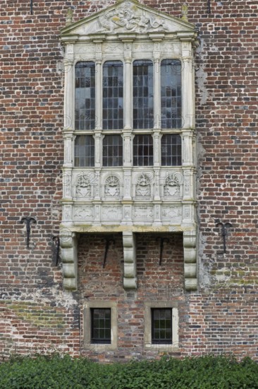 A richly decorated Gothic bay window on an old brick wall, Raesfeld moated castle, Münsterland,
