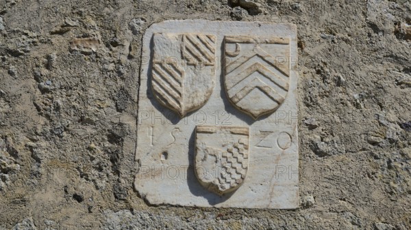 Coat of arms of the Grand Master del Carretto, close-up of stone coat of arms on a historic wall,