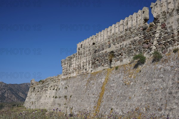 Defence wall, Outer wall, Extensive stone fortifications with vegetation under blue sky,