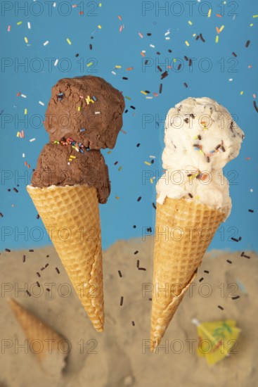 Chocolate and vanilla ice cream in wafers against a blue background with sprinkles
