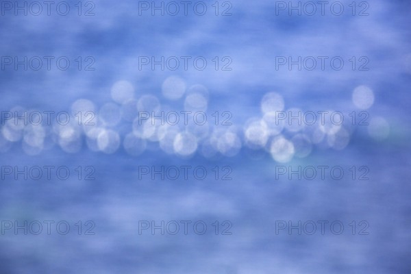 White light reflections, bokehballs on blue sea, water surface, Germany