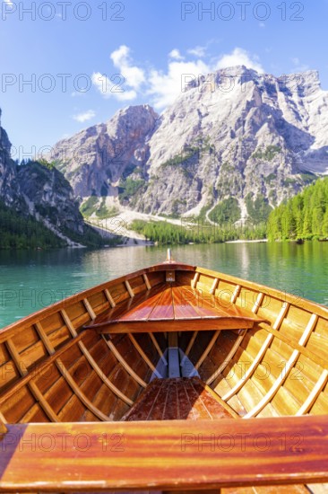 View from the boat onto a calm lake with surrounding mountain panorama under a clear sky, Lake