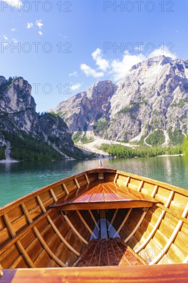 Perspective from the boat towards the majestic mountain landscape over clear water, Pragser