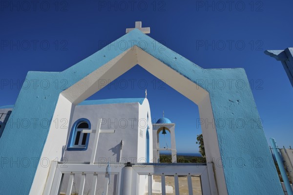 Chapel of Agios Charalambos, Mediterranean church in blue and white under a bright blue sky,