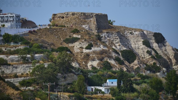 Castle, Historic ruins on an overgrown hill overlooking a rocky landscape under a blue sky,