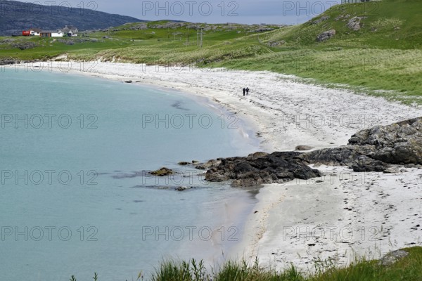 A quiet beach with white sand, green grass and a cloudy sky, Eriksay, Hebrides, Scotland, United