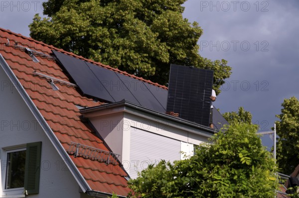 Tradesmen install solar panels, solar modules, solar panels, solar collectors, on house roof,
