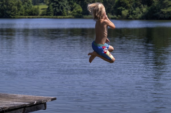 Boy, 6 years, blond, jumping from wooden footbridge, footbridge into the water, bathing lake, lake,