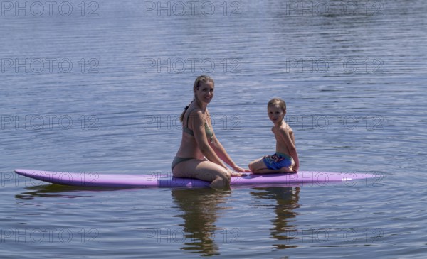 Mother, woman, blonde, in bikini and son, boy, 6 years, sitting on board, surfboard, surfboard,