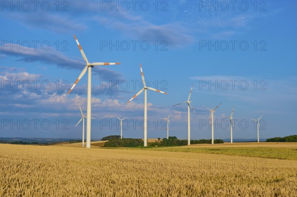 A wind farm on wide fields with several wind turbines under a blue sky, summer, Höhefeld, Wertheim,