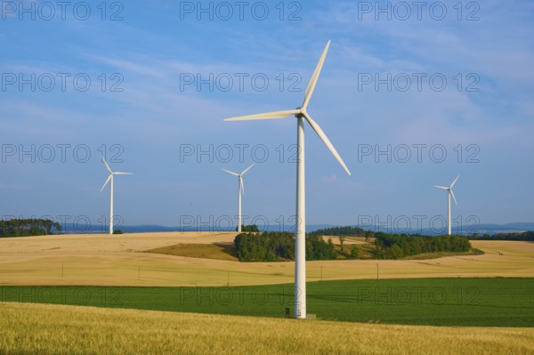 Wind turbines stand on fields stretching under a cloudy sky, summer, Höhefeld, Wertheim,