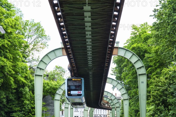 The Wuppertal suspension railway runs through Vohwinkel in front of buildings from the Wilhelminian