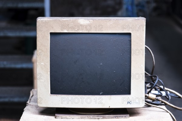An old, dusty CRT monitor (cathode ray tube monitor) with a beige-grey housing. Significant signs