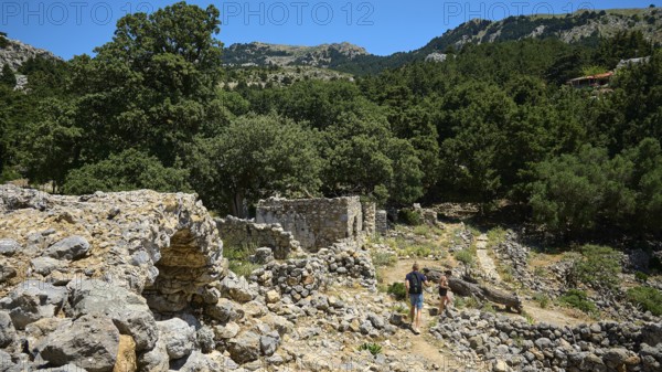 Two people explore ancient ruins surrounded by mountains and forests, Abandoned Village, Lost