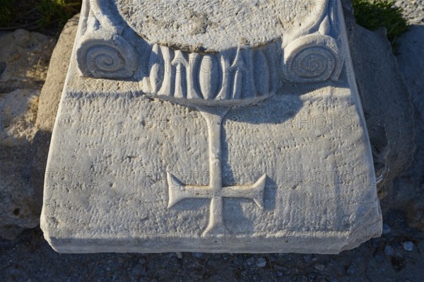 Detail of a stone pedestal with engraved cross and decorations, Agios Stefanos Beach, Agios