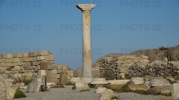 Ruins with a towering ancient column against a clear sky, Agios Stefanos Beach, Agios Stefanos