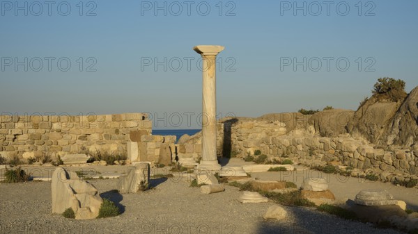 Historic site with a single preserved column surrounded by ancient walls and sea views, Agios