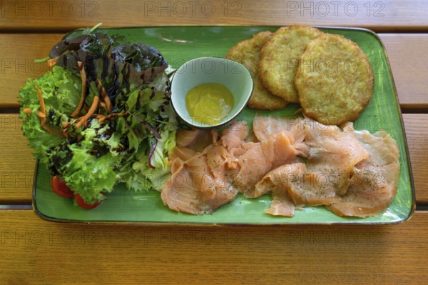 Salmon with baggers, potato pancakes and salad, served in a beer garden, Franconia, Bavaria,