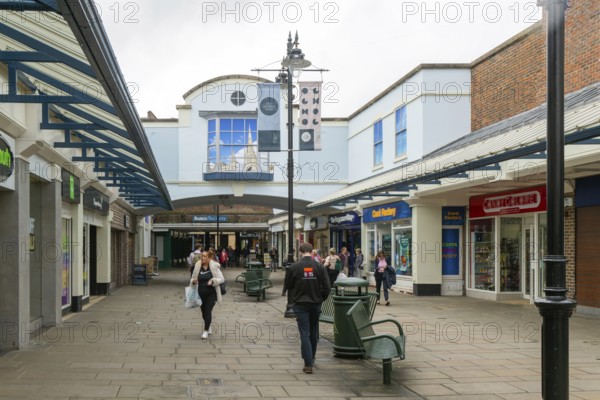 Shopper walking in Old George Mall shopping centre, Salisbury, Wiltshire, England, UK