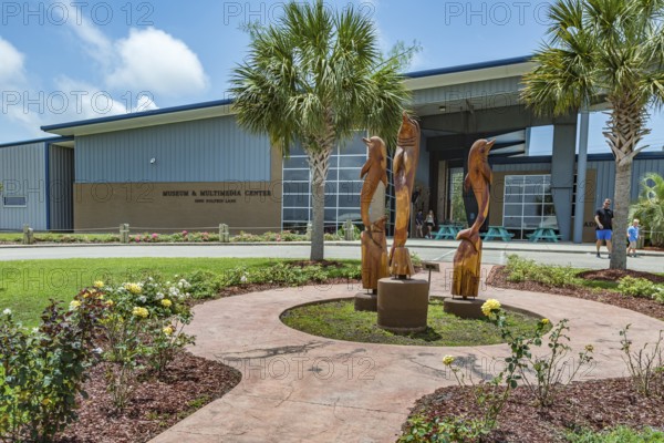 Carved wooden dolphins outside the Museum and Multimedia center at Ocean Adventures Marine Park in