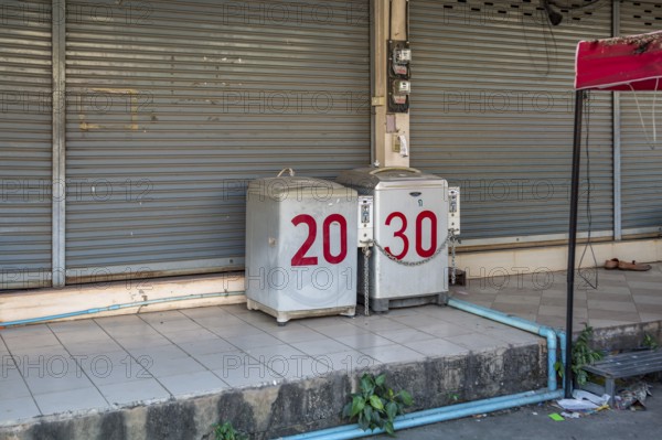 Coin operated laundry washing machines on sidewalk in Chiang Rai province of Northern Thailand
