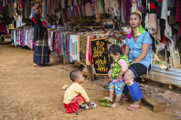 Tribal woman with two children in the Long Neck Karen tribe (more properly called the Kayah Lahwi