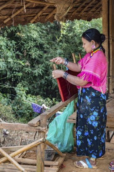 Woman weaving items to sell at the Union of Hill Tribe Villages outside of Chiang Rai in the