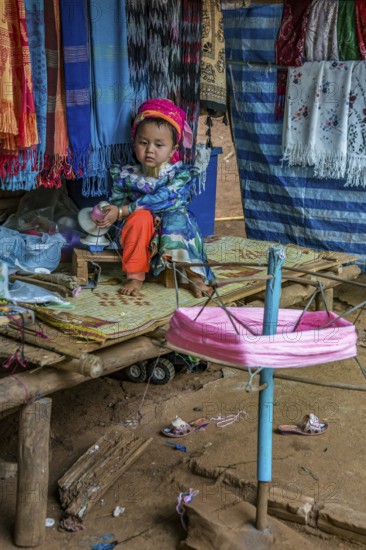 Tribal child spooling yarn for weaving scarves to be sold in the Long Neck Karen tribe (more
