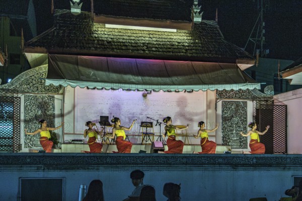 Traditional Thai dancers perform on a lighted stage at the night market in downtown Chiang Rai,
