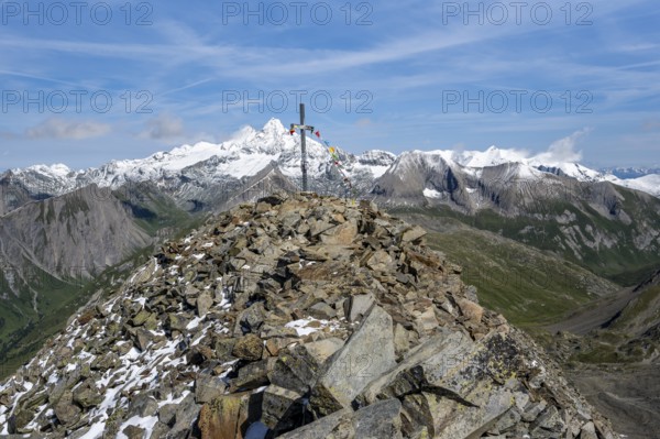 Böses Weibl summit with summit cross and colourful prayer flags, view of picturesque mountain