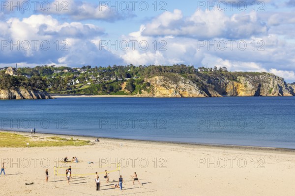 Young people playing beach volleyball on a sand beach a sunny summer day by the sea, Crozon