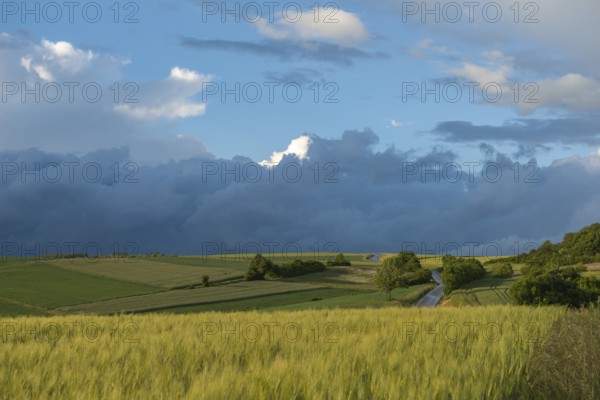 Dramatic cloudy sky with approaching storm and last rays of sunshine, Frankenhain, dark cloud wall,