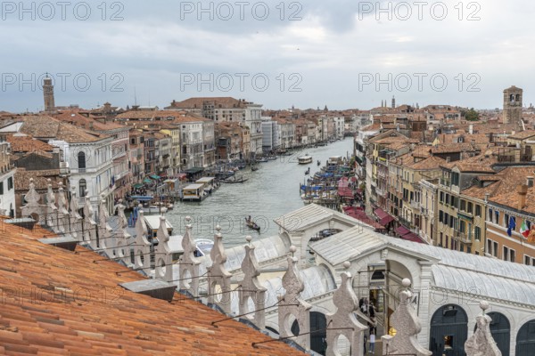 Gondolas navigating the grand canal amidst historic buildings in venice, italy, seen from a rooftop