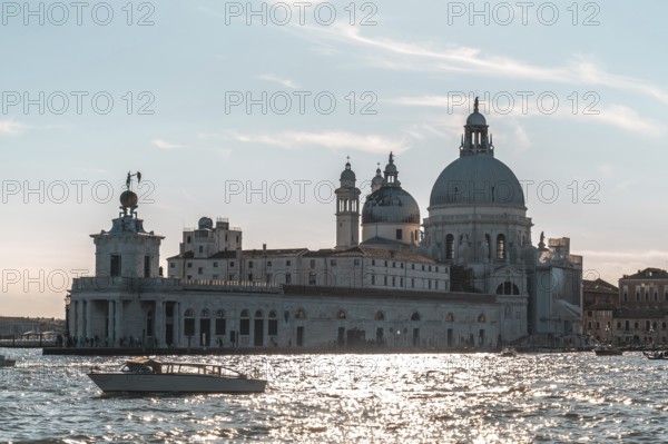 Motorboat navigating grand canal with punta della dogana and basilica di santa maria della salute