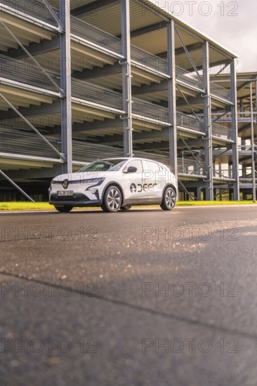 White Renault car in front of a multi-storey car park from a low perspective, Renault Megane, Deer