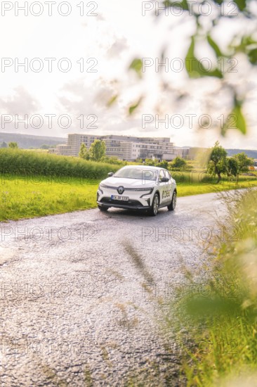 Renault car on a lonely road with trees and buildings in the background, Renault Megane, Deer E