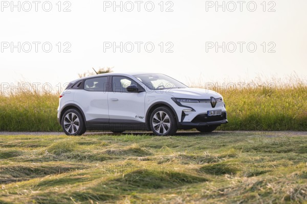 White electric car standing in a meadow on a sunny day, Renault Megane, Deer E- Carsharing,