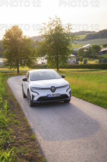 White car driving on a country road at sunset, surrounded by trees, Renault Megane, Deer E-