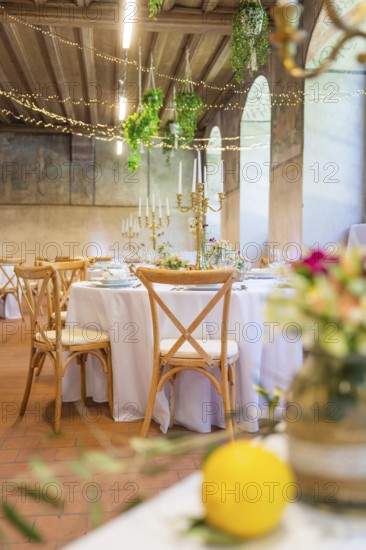 Elegant wedding decoration in a rustic ballroom with candles and flower arrangements, event and