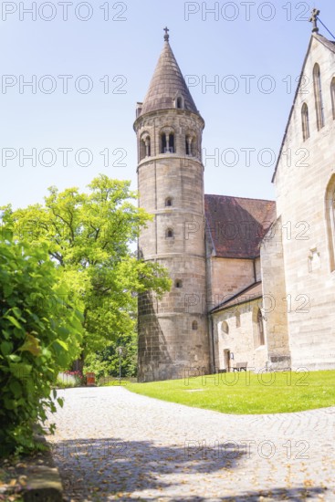 Medieval stone church tower next to a green path in summer light, event and wedding location Lorch