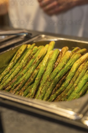 Seasoned green asparagus on a tray in a kitchen ready to be served, event and wedding location