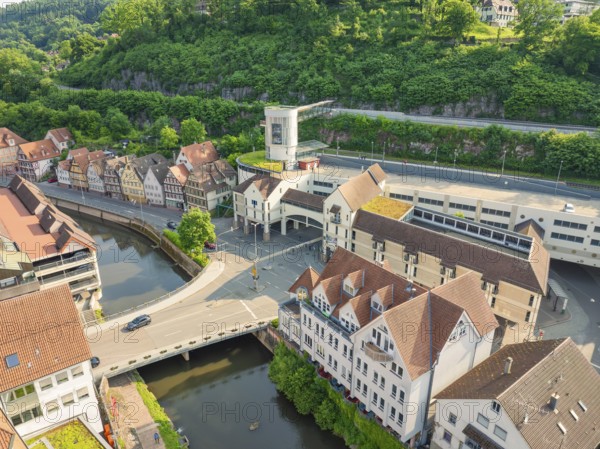 Mixture of modern and historic buildings on a river, surrounded by greenery, Calw, Black Forest,
