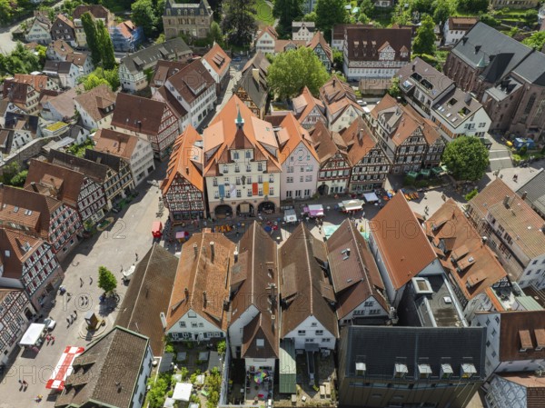 Aerial view of an old town with half-timbered houses and a busy square in an urban environment,