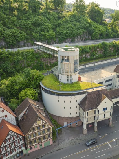 Modern building with green roof next to historic half-timbered houses on a cliff, Calw, Black