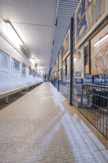 Long corridor in a gallery, lined with works of art on the walls, historical art exhibition in the