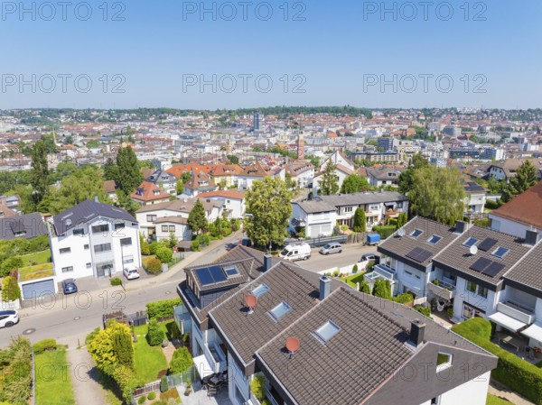 Bird's eye view of a residential neighbourhood with tiled roofs against an urban backdrop, roof