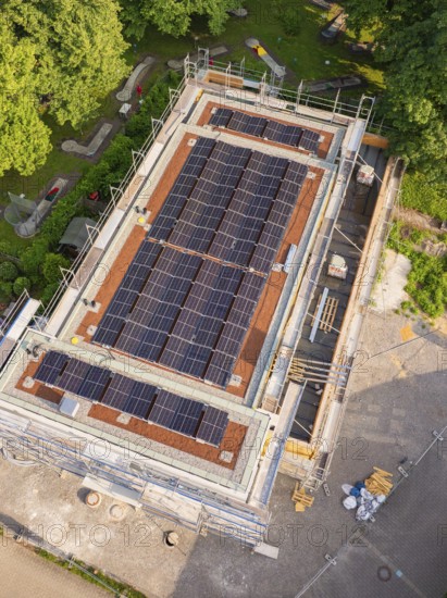 Close-up of a roof with installed solar cells on a construction site with scaffolding in summery