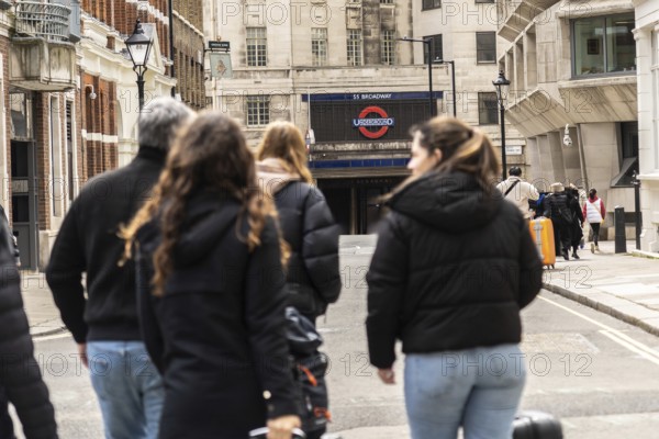 Tourists walking on a london street towards st. Paul's tube station, a major transportation hub in
